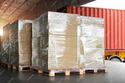 a pallet of shrinked wrapped cardboard boxes in a warehouse