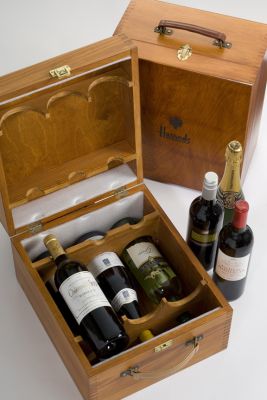wood presentation box for wine and champagne on a table, it is opened displaying the bottles