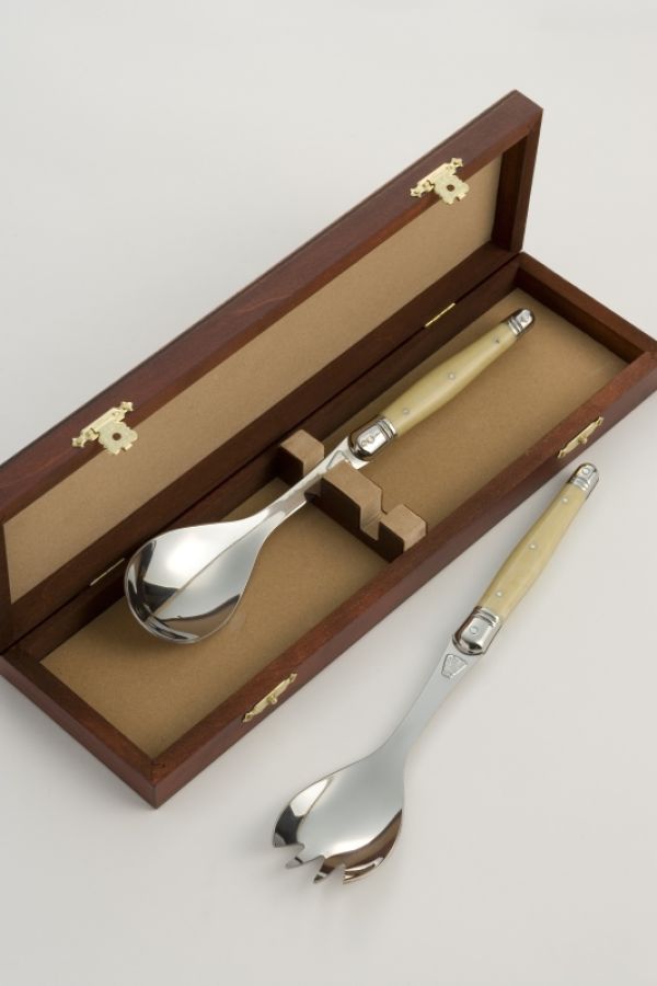 A wooden box with serving spoons displayed inside