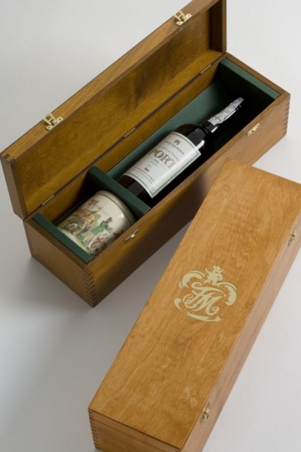 two wooden boxes on a table, one is opened showing a bottle of port and a jar of Stilton Cheese