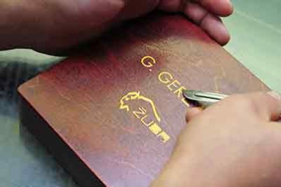 a person colouring the top of a wooden bo with a laser etching instrument