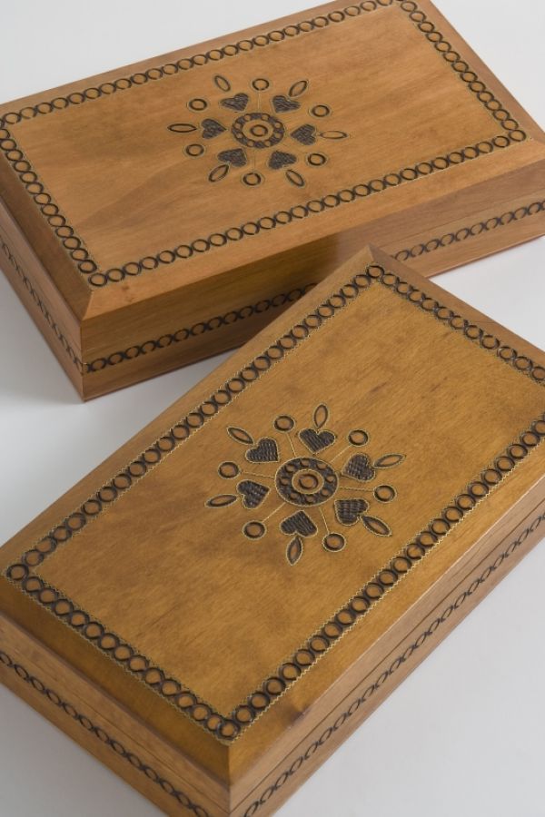 two wooden decorative boxes with a motif design on them