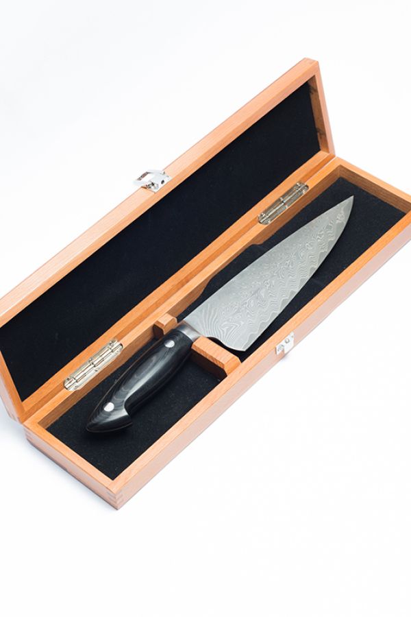 A wooden box with a large butcher's knife displayed inside