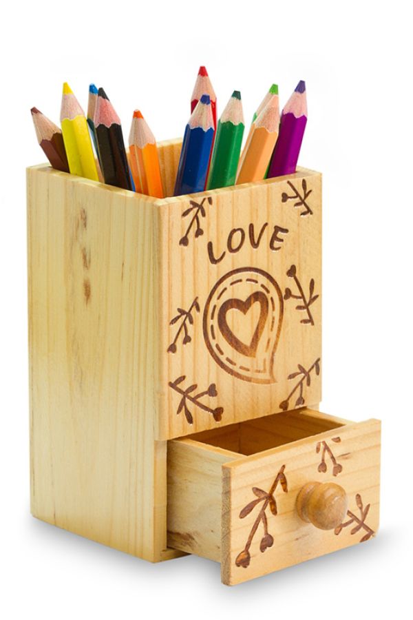 a square wooden pencil holder with a drawer at the bottom, it is decorated and has coloured pencils in it