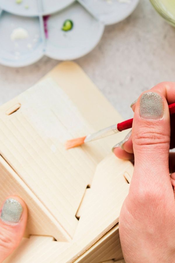 a person painting a wooden box
