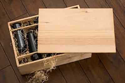 wooden wine case with bottles of wine laying on wood wool packing